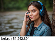 Девушка в современных наушниках слушает музыку, аудиокнигу. Стоковое AI-изображение, AI-художник Руслан Лесков / Фотобанк Лори