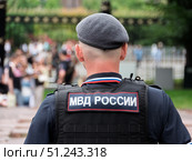 Russian Police Officer in Uniform Overseeing Crowd. Редакционное фото, фотограф Sergakoff / Фотобанк Лори