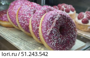 Enjoy delightful Pink Frosted Donuts with colorful sprinkles, perfect for any occasion. A wonderfully tempting display of pink frosted donuts that are beautifully topped with colorful sprinkles. Стоковое видео, видеограф worker / Фотобанк Лори