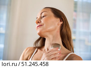 Middle-aged Woman Uses Electrical Device to Rejuvenate Her Skin While Relaxing Indoors. Стоковое фото, фотограф Aleksandr Golubev / Фотобанк Лори