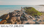 Beautiful woman walking on rocky outcrop overlooking calm blue ocean in Mexico. Стоковое видео, видеограф Ольга Сухарева / Фотобанк Лори