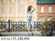 portrait of a girl in jeans and a t-shirt on the background of the building in the evening on a summer day. street dancing in the city. Стоковое фото, фотограф Арзюков Вадим Николаевич / Фотобанк Лори