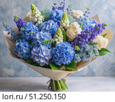 A Vibrant Bouquet of Blue Hydrangeas and Delphiniums on a Rustic Table. Generative AI. Стоковое AI-изображение, AI-художник Roman Zavorotny / Фотобанк Лори