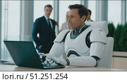 Futuristic humanoid robot with sleek design is working on a laptop in a modern office environment, surrounded by business professionals, showcasing advanced technology and collaboration. Стоковое AI-видео, аниматор Ирина Ручушкина / Фотобанк Лори