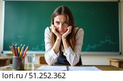 Разгневанный учитель сидит за столом и смотрит в кадр. The angry teacher sits at the table and looks into the frame. Стоковое AI-изображение, AI-художник ketpro.design / Фотобанк Лори