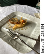 Empty dessert plate with leftover pastry and crumbs on decorative white tablecloth. Стоковое фото, фотограф Анастасия Золотницкая / Фотобанк Лори