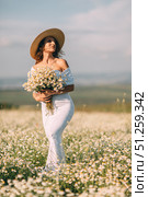 Daisies Woman Field: Woman holds flowers in daisy field during summer day, enjoying peaceful nature. Стоковое фото, фотограф svetograph / Фотобанк Лори