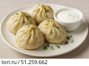 A delectable serving of homemade dumplings garnished with fresh herbs, accompanied by a creamy sauce for an irresistible culinary experience. Стоковое AI-изображение, AI-художник Башкирова Анна / Фотобанк Лори
