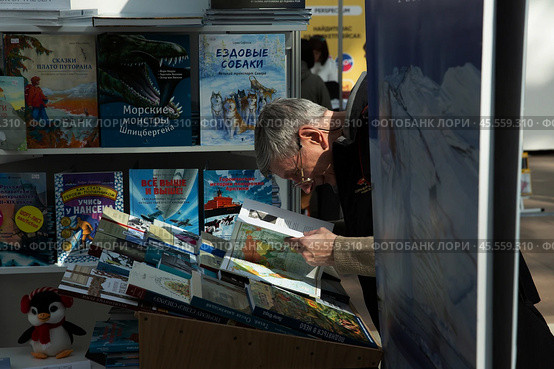 06.04.2023, Москва. Международная ярмарка интеллектуальной литературы «non/fictioNвесна» в Гостином дворе. Мужчина всматривается в книгу. Редакционное фото, фотограф Дмитрий Киселёв / Фотобанк Лори