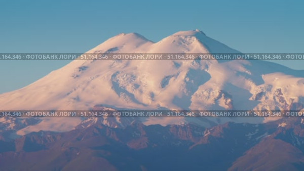 4k, A panoramic view of the snow-capped peaks of Mount Elbrus, the highest point of the European continent, against a clear blue sky, at daytime, Stavropol Krai, Russia. Стоковое видео, видеограф Сергей Богомяко / Фотобанк Лори