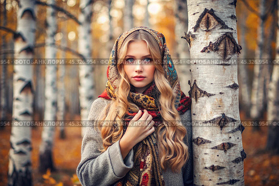 A beautiful girl in a traditional Russian folk shawl in a autumn birch grove. The portrait symbolizes the traditions and beauty of the Russian people. Стоковое AI-изображение, AI-художник Photojuli / Фотобанк Лори