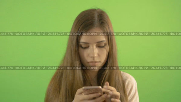 A beautiful model looks and reads on the tablet. On the background of a green screen. Стоковое видео, видеограф Игорь Усачев / Фотобанк Лори