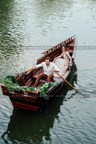 a boat trip for a guy and a girl along the canals and bays of the river overgrown with wild willows. Стоковое фото, агентство Ingram Publishing / Фотобанк Лори
