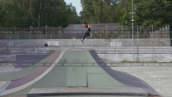 A boy rides a scooter in a skate park. Children's leisure. Moscow. Kuzminki. 17.08.2024. Редакционное видео, видеограф Ярославский Максим / Фотобанк Лори