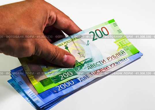A bundle of money in his hand. Russian rubles. Banknotes of 200 and 2000 rubles. Стоковое фото, фотограф Леонид Еремейчук / Фотобанк Лори