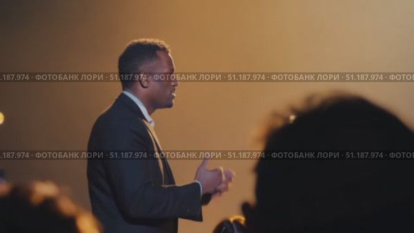 A captivating speaker shares powerful insights with an enthusiastic audience during a late-night gathering. Стоковое AI-видео, аниматор Данила Большаков / Фотобанк Лори