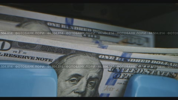 A close-up of a hundred dollar bill being deposited into a machine. Стоковое видео, видеограф Сергей Толмачёв / Фотобанк Лори