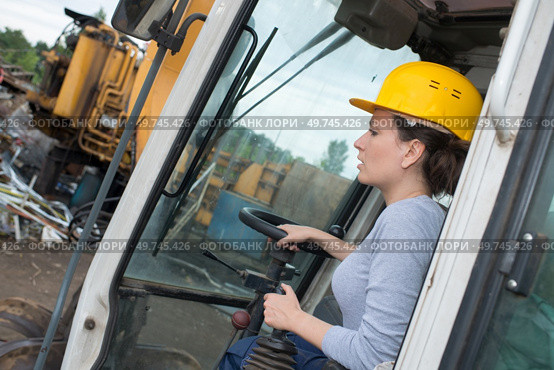 a construction worker driving digger. Стоковое фото, агентство Ingram Publishing / Фотобанк Лори