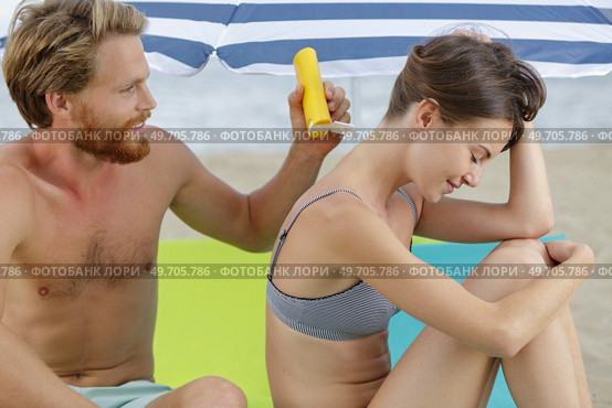 a couple applying the suncream. Стоковое фото, агентство Ingram Publishing / Фотобанк Лори