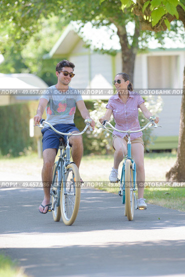 a couple is biking in the campsite. Стоковое фото, агентство Ingram Publishing / Фотобанк Лори