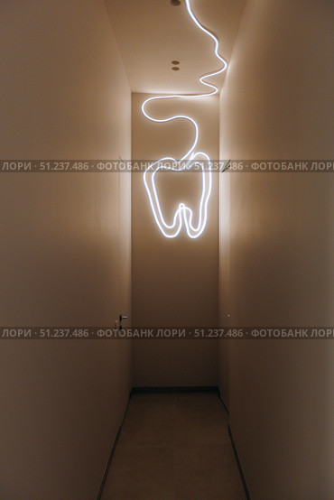 A Creative Dental Corridor Enhanced With a Striking Neon Tooth Light for Visual Impact. Стоковое фото, фотограф Cantemir Dumitru / Фотобанк Лори