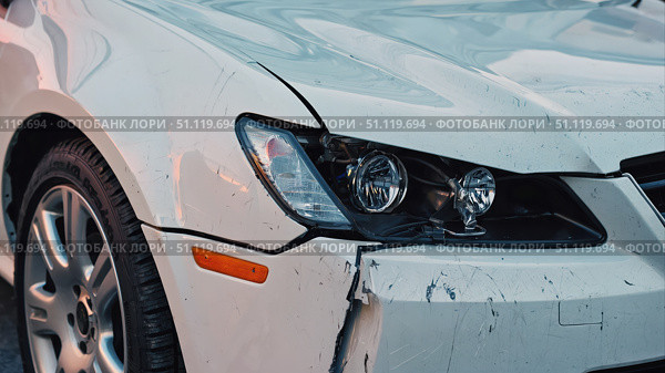 A damaged white car with noticeable scratches and dents on the front bumper and fender. Damage to the headlight is also visible, which indicates the need for repair. Стоковое AI-изображение, AI-художник Светлана  Громак / Фотобанк Лори