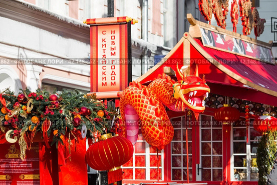 A dragon and Chinese red Christmas lanterns on Tverskaya Street in Moscow. Close-up. The first ever meeting of the Chinese New Year 2024 in Moscow. Стоковое фото, фотограф Photojuli / Фотобанк Лори