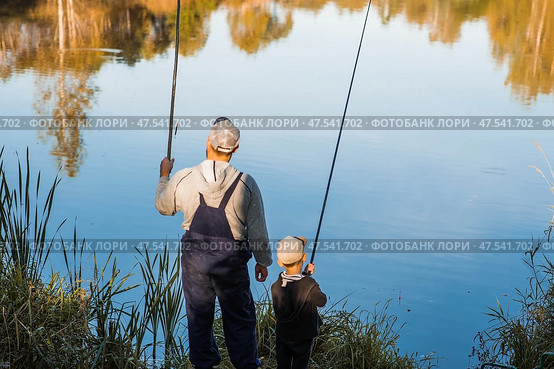 A father and son fishing on a warm autumn day on a pond. Стоковое фото, фотограф Photojuli / Фотобанк Лори