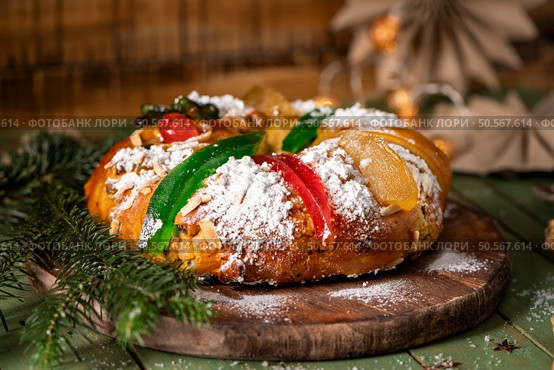 A festive King Cake adorned with colorful candied fruits, dusted with powdered sugar, and ready to be shared. Стоковое фото, агентство Ingram Publishing / Фотобанк Лори