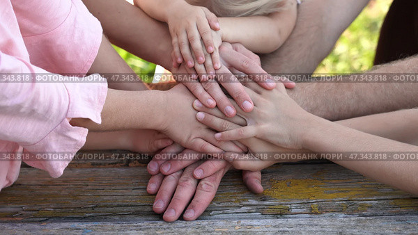 A friendly family joins their hands as a sign of joint success. Стоковое фото, фотограф Mikhail Davidovich / Фотобанк Лори