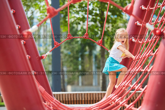A girl climbs a rope attraction in the park. Entertainment for children. Стоковое фото, фотограф Наталия Кирсанова / Фотобанк Лори