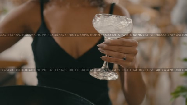 A girl in a black dress pours an alcoholic drink with ice at an event. Стоковое видео, видеограф Tatiana Malinsky / Фотобанк Лори