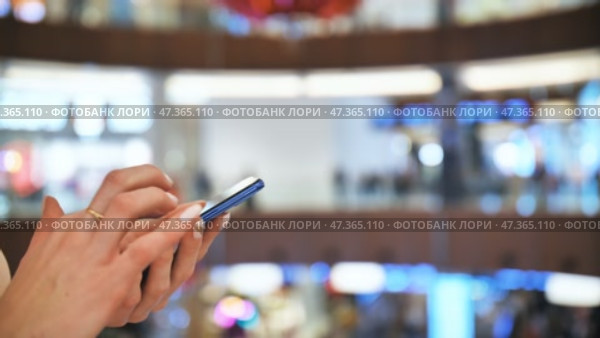 A girl in a shopping mall dials a message on the phone. Hands close up. Стоковое видео, видеограф Mikhail Davidovich / Фотобанк Лори