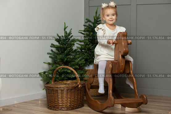 A girl on a horse gurney in a Christmas room. Стоковое фото, фотограф Лазаренко Светлана / Фотобанк Лори