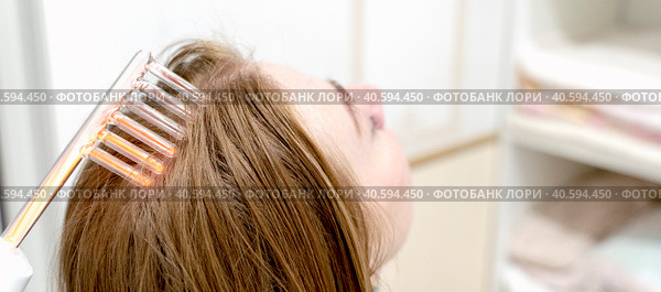 A girl on the procedure of darsonvalization of hair (2023 год). Редакционное фото, фотограф Igor Skripachev / Фотобанк Лори
