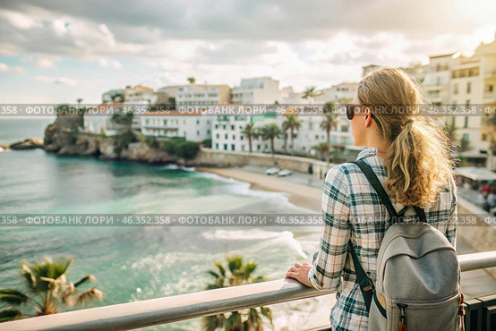A girl traveler with a backpack on the background of the southern coast of the sea. A woman travels, enjoys life and the environment. Tourism. Стоковое AI-изображение, AI-художник Photojuli / Фотобанк Лори