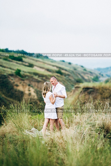 a guy with a girl in light clothes on the background of a green canyon of erosion of the earth. Стоковое фото, агентство Ingram Publishing / Фотобанк Лори
