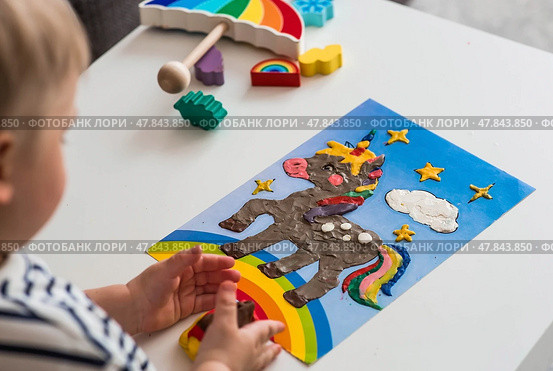 A little boy is playing with plasticine. Fine motor skills-developing games for children. The kid makes a horse. Useful games for child development. Стоковое фото, фотограф Photojuli / Фотобанк Лори