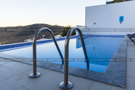 A luxurious outdoor pool with stainless steel handrails. Стоковое фото, фотограф EugeneSergeev / Фотобанк Лори