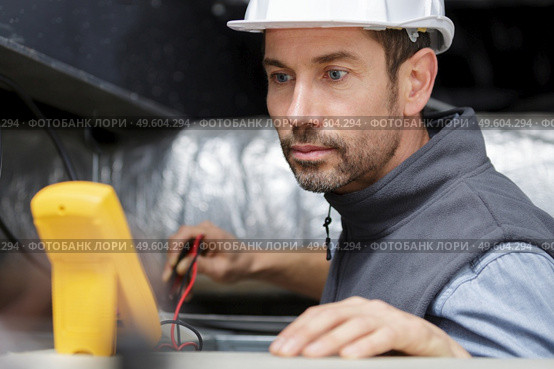 a male electrician checking fusebox. Стоковое фото, агентство Ingram Publishing / Фотобанк Лори