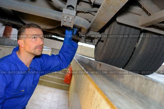 a male mechanic fixing a vehicle. Стоковое фото, агентство Ingram Publishing / Фотобанк Лори