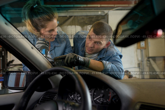 a man and woman changing windshield. Стоковое фото, агентство Ingram Publishing / Фотобанк Лори