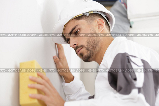 a man cleaning wall surface. Стоковое фото, агентство Ingram Publishing / Фотобанк Лори