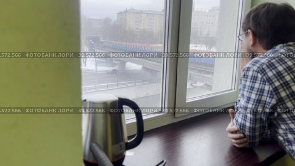 A man comes to the window and looks at the city landscape. Household sketch. Стоковое видео, видеограф Ярославский Максим / Фотобанк Лори