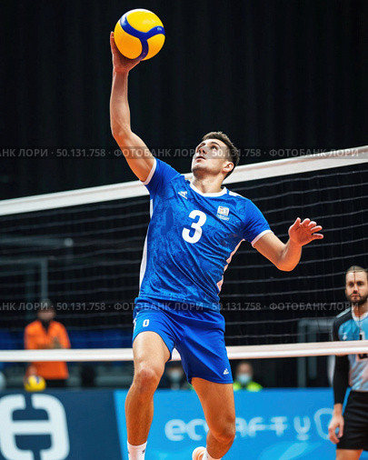 A man in a blue shirt and blue shorts is jumping to hit a volleyball. Стоковое AI-изображение, AI-художник Ярославский Максим / Фотобанк Лори