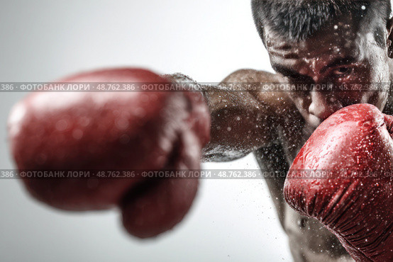 A man is boxing with his red gloves on. Стоковое AI-изображение, AI-художник Ярославский Максим / Фотобанк Лори