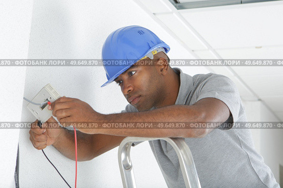 a man is installing wiring. Стоковое фото, агентство Ingram Publishing / Фотобанк Лори