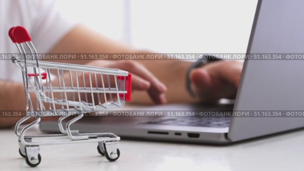 A man makes online purchases through a laptop on marketplaces. Стоковое видео, видеограф Igor Skripachev / Фотобанк Лори