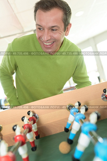 a man playing table football. Стоковое фото, агентство Ingram Publishing / Фотобанк Лори