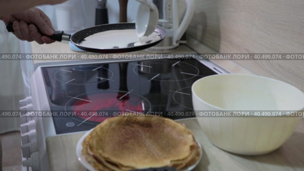A man pours dough into a flat frying pan. Cooking pancakes at home. Стоковое видео, видеограф Юрий Поздников / Фотобанк Лори